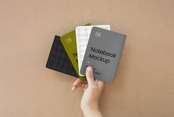 Front view, four A5 Notebook Cover Mockup in men's hand against the wall.