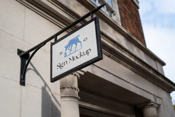 Rectangle Hanging Sign Mockup in a with a black frame on the background of the tenement house.
