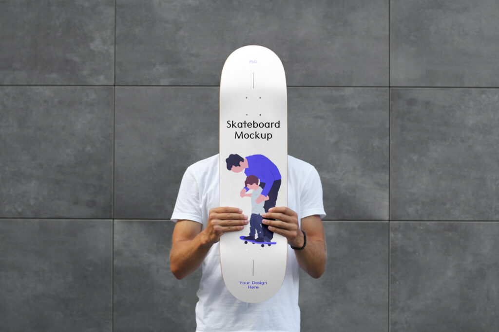 Men standing and holding a Skateboard Mockup in front of his face against a modern building.