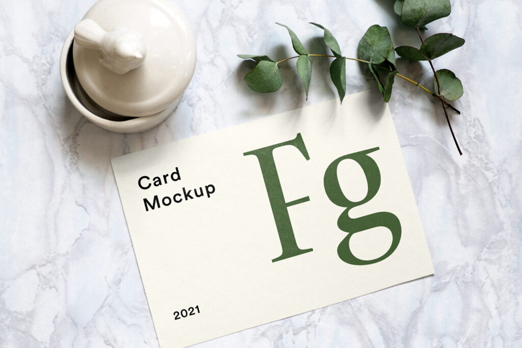 Seen from above, a Paper Square Card PSD Mockup lies on the marble floor.