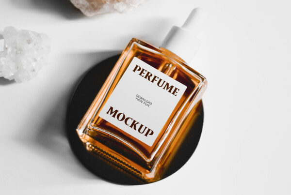 The Glass Perfume Falcon Bottle Mockup with label seen from above lie on the black small plate among the crystals.