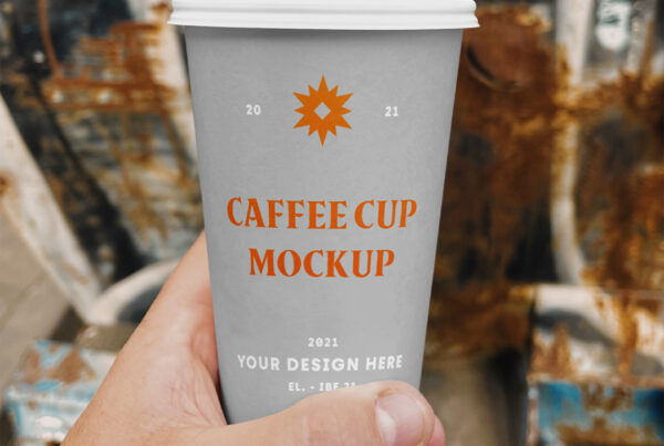Front view, Coffee Cup Mockup in men's hand against street graffiti wall.