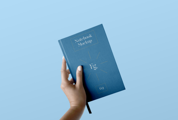 Front view, Hard Cover Notebook with Hand Mockup on the blue background.