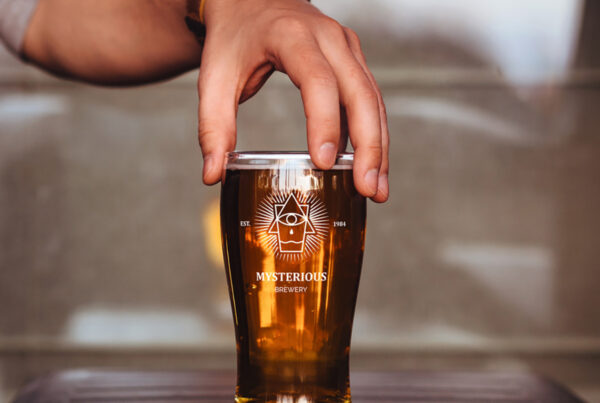 Men holding Beer Glass Mockup from above.