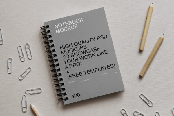 Simple bound paper Notebook Mockup lie on white cardboard between office accessories.