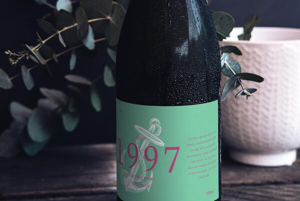 Glass Wine Bottle Mockup with paper label standing on the dark wood table.