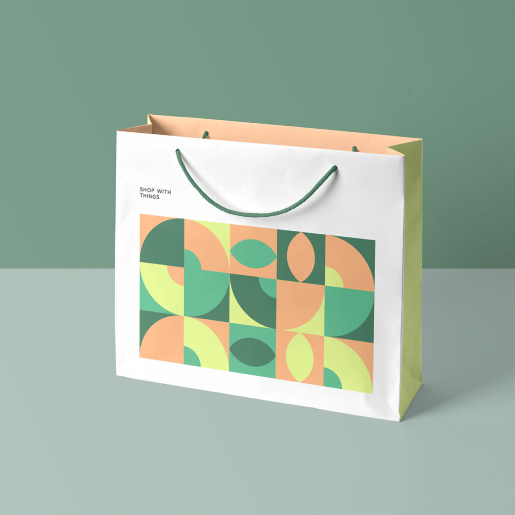Open paper Shopping Bag Mockup standing on bright green floor in studio.