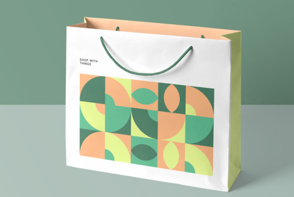 Open paper Shopping Bag Mockup standing on bright green floor in studio.