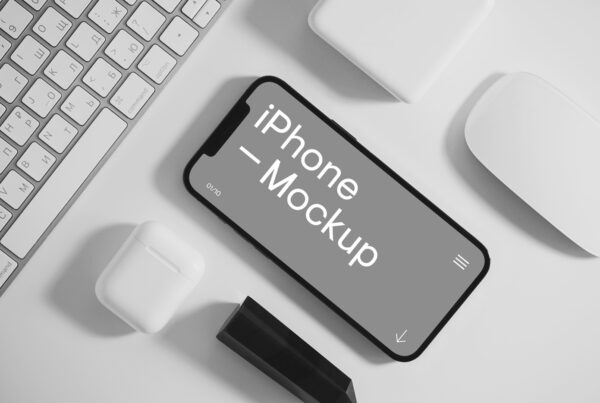 iPhone mockup between Apple accessories on the white desk.