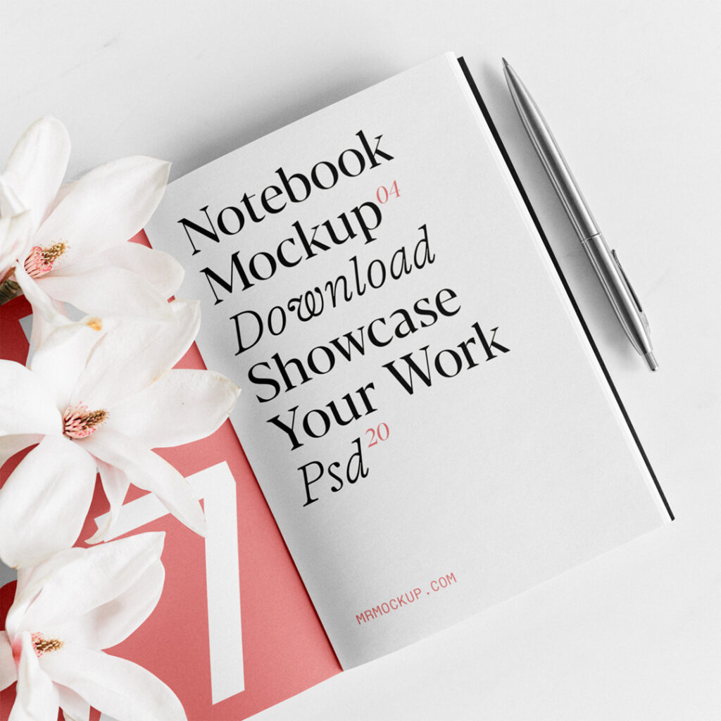 An open notebook mockup with flowers laying on the floor.
