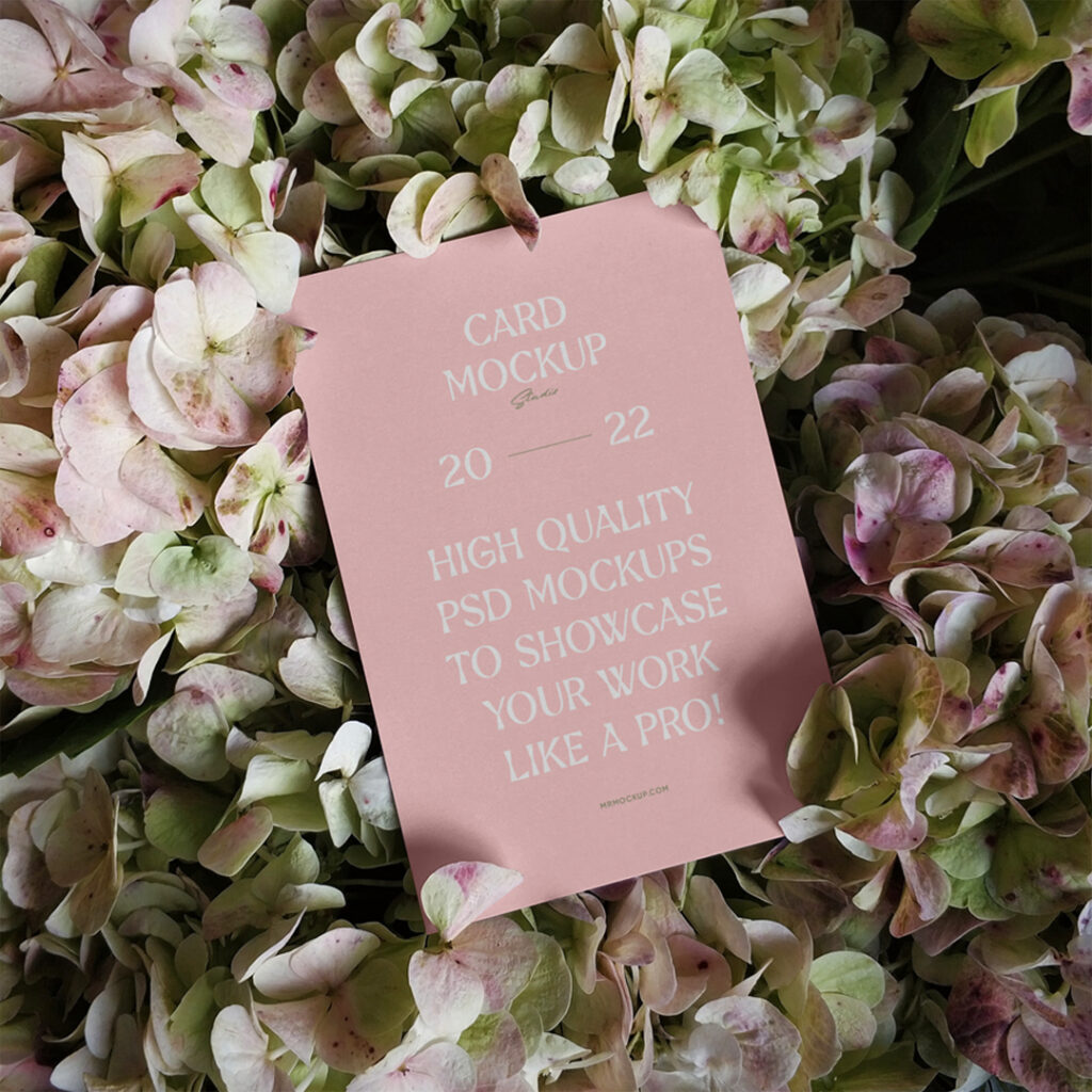 The card mockup lies between flowers.