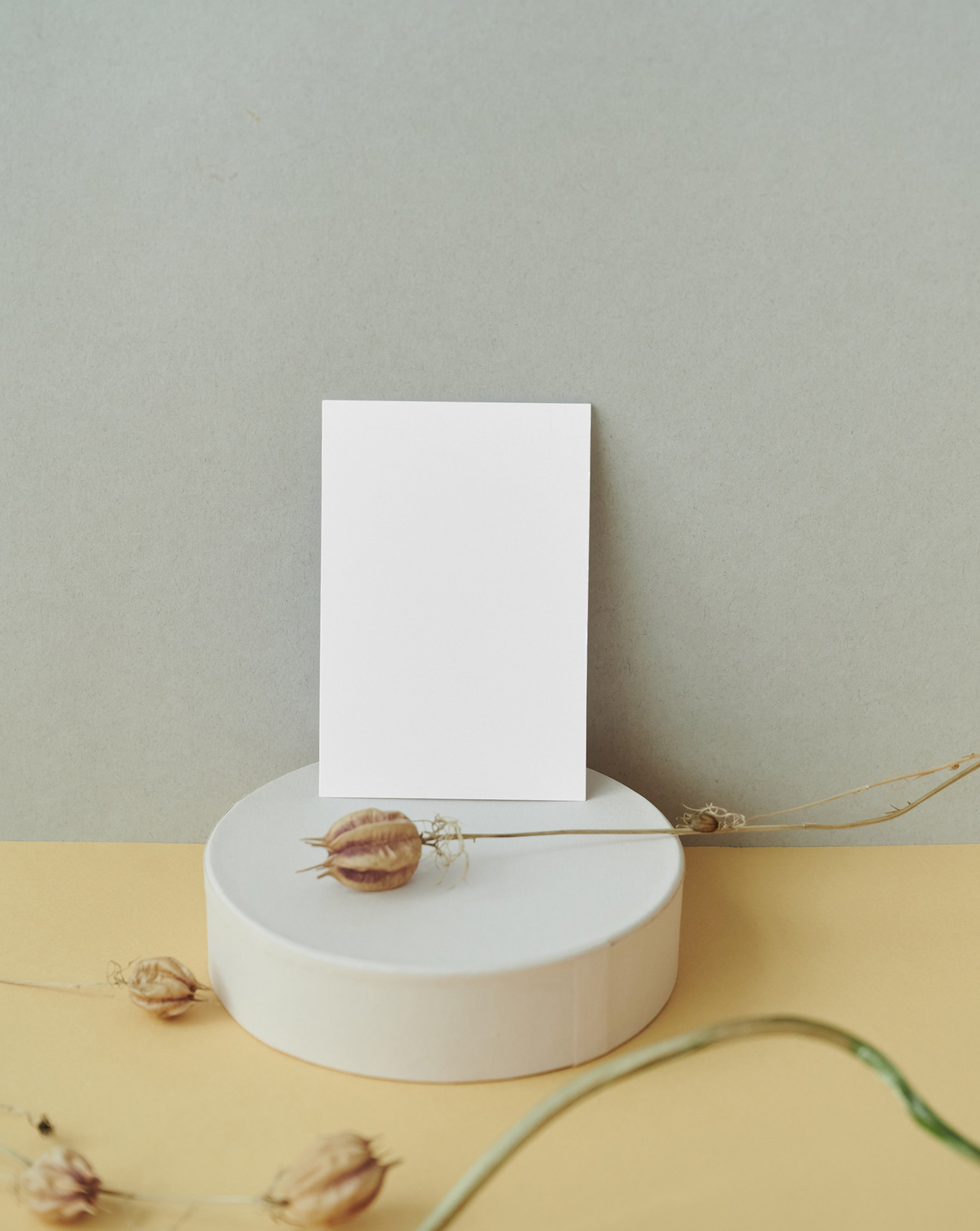 The card mockup is placed on the desk with decorations, seen from the front.