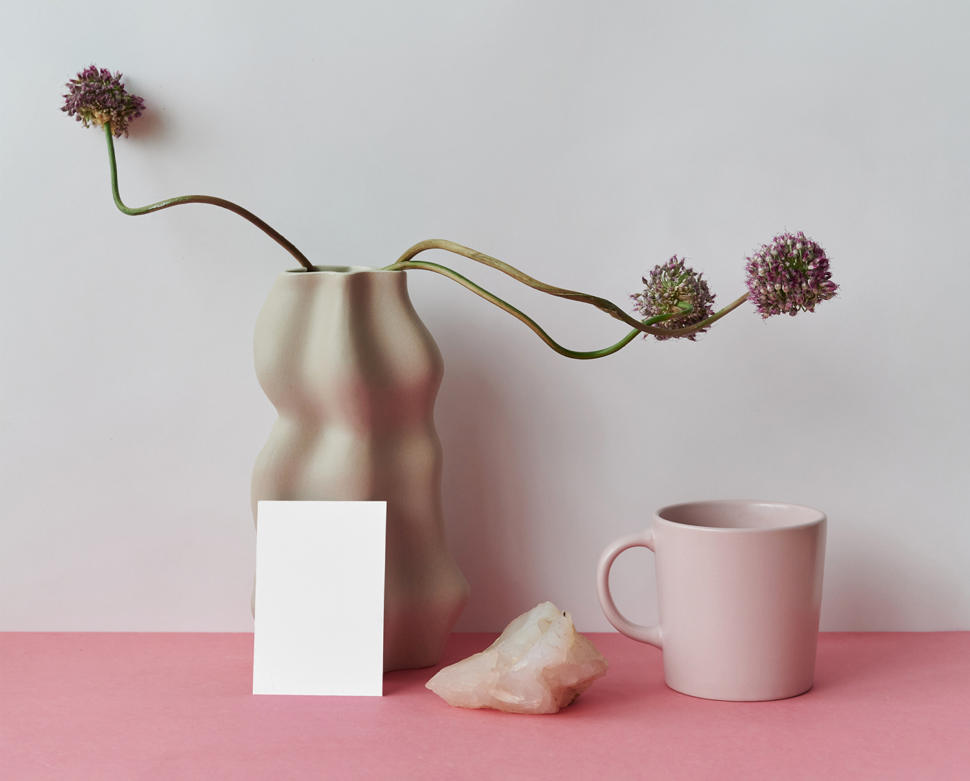 The card mockup is placed on the table with decorations and vases seen from the front.