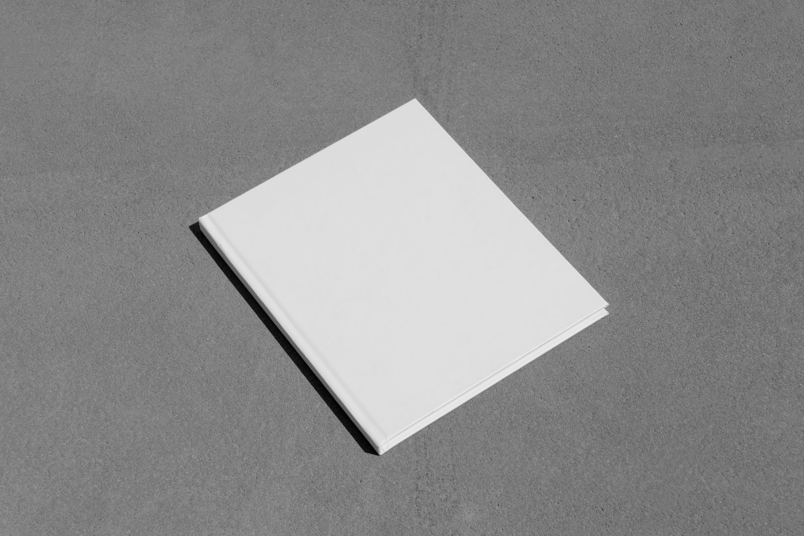 White book laying on the concrete floor from outdoor branding mockups