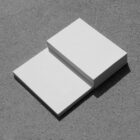 White business cards on the concrete floor from outdoor branding mockups.