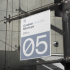 Hanging poster on the modern building from outdoor branding mockups.