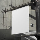 Hanging white poster on the modern building from outdoor branding mockups.