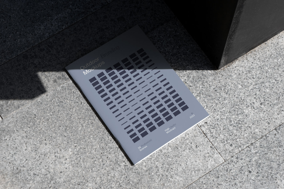 Notebook with blue project, on the granite floor from outdoor branding mockups.