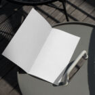 White brochure on the metal table from outdoor branding mockups.