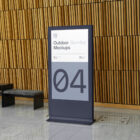 Plastic stand project in front of wooden wall made with outdoor branding mockups.