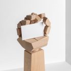 Seen from the front, a huge Wood Hand holding a white Business Card Branding Mockup against a white background.