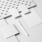 A set of White Branding Mockups elements like business cards, envelope, pen, and company paper in composition with texture seen from the above.