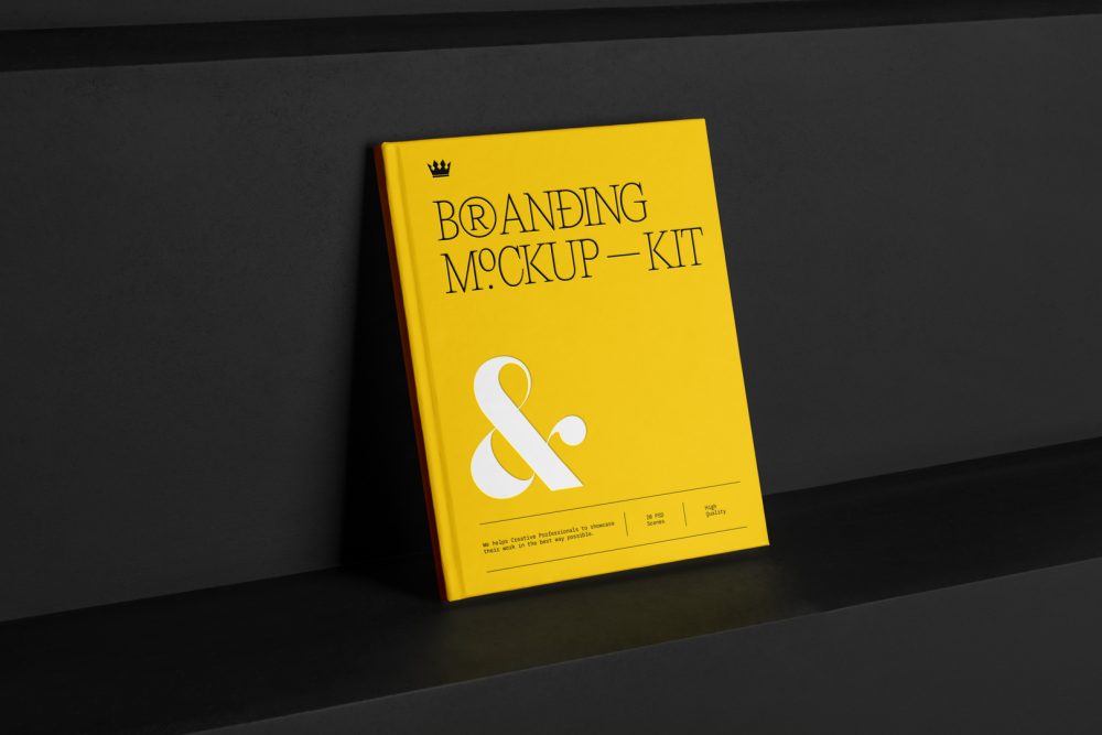 Hardcover Book Branding Mockups Kit with deboss yellow design seen from the front is standing on the black wooden stairs.