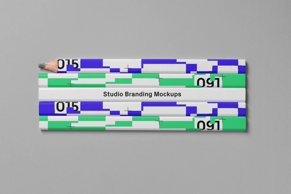 Seen from the above composition of five flat Pencils Branding Mockups laying on the gray floor in the studio.