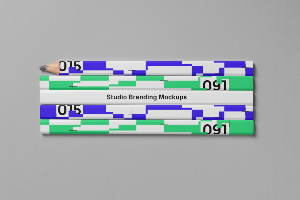 Seen from the above composition of five flat Pencils Branding Mockups laying on the gray floor in the studio.
