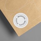 Big zoom on the circle Sticker Branding Mockup glued to craft card against a gray background.