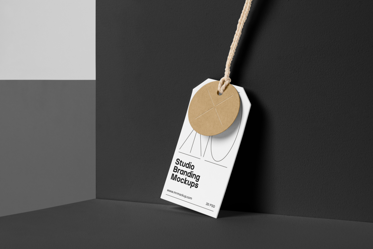 Craft circle label, and White rectangle Label Branding Mockup hooked on a craft string standing against the background of a black wall.