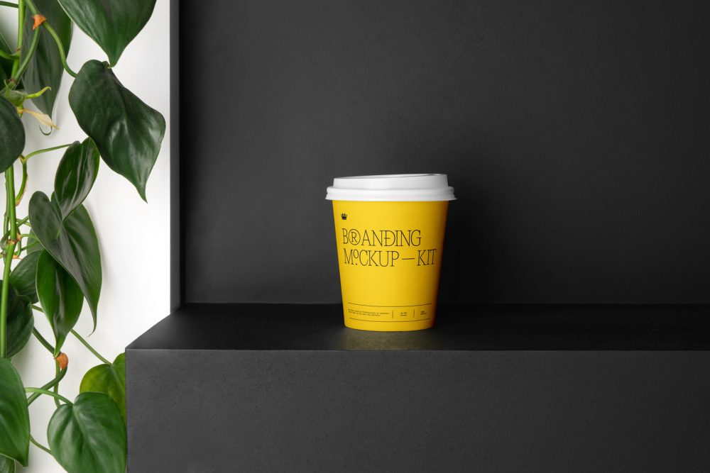 Coffee Cup Branding Mockup with yellow design scene seen from front standing on the black wooden stairs.
