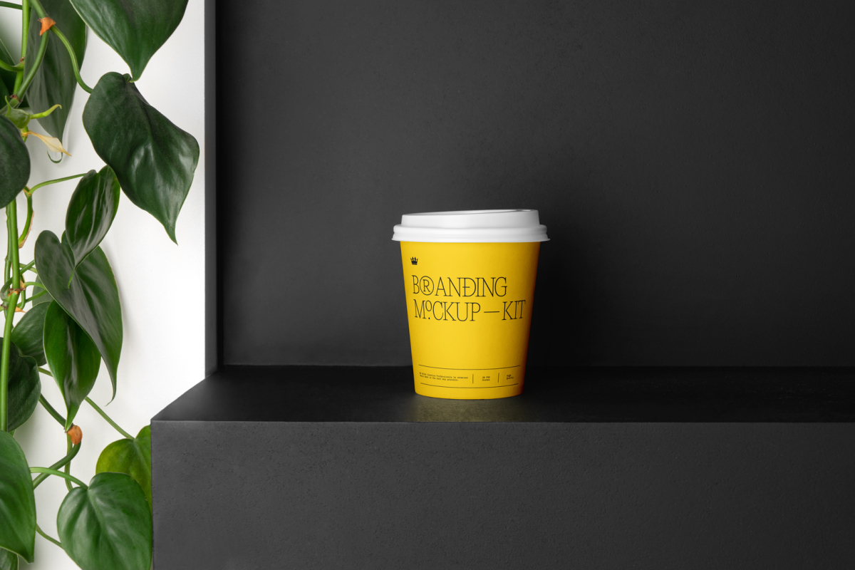 Coffee Cup Branding Mockup with yellow design scene seen from front standing on the black wooden stairs.