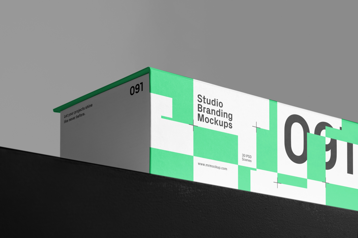 Viewed from below at an angle, a Box Branding Mockup with a modern green design is standing on a black box against a gray background.