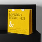Decorative Paper Bag Branding Mockups Kit with a yellow design seen from front, is standing on the black wooden stairs.