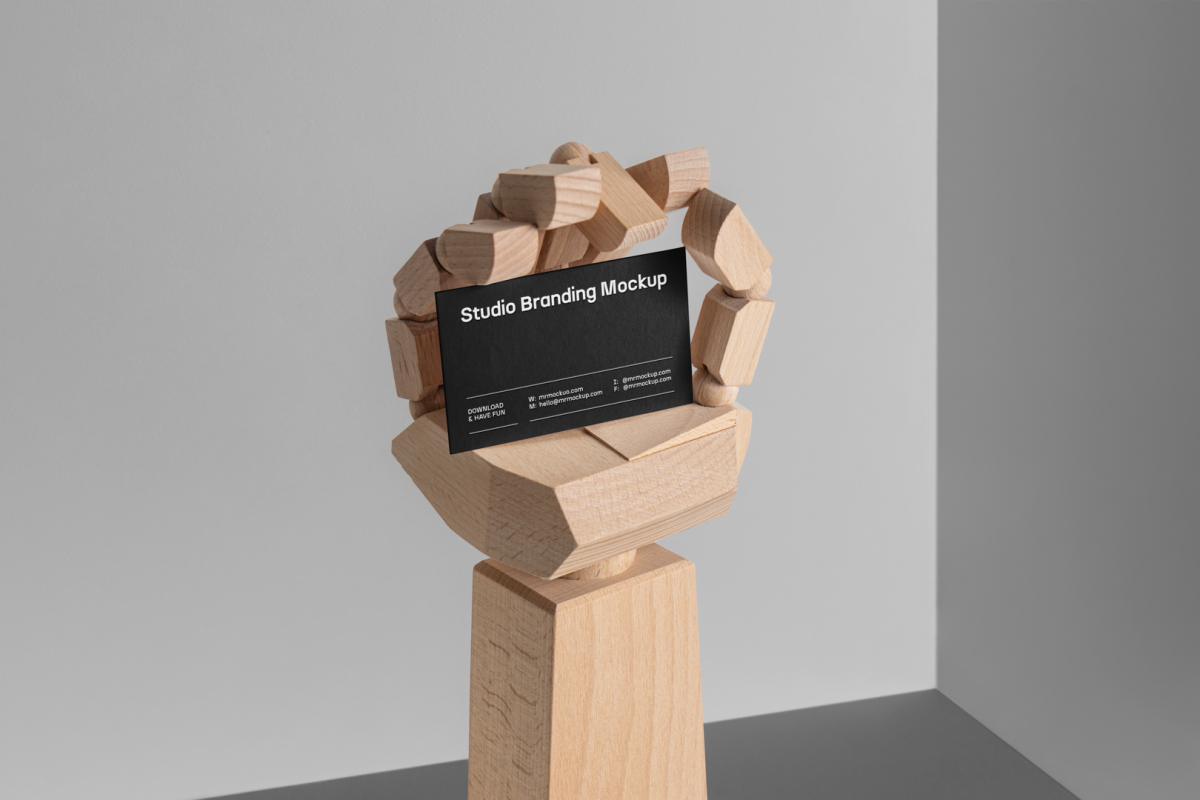 Huge Wood Hand holding a black Business Card Branding Mockup seen from the front on a gray background.