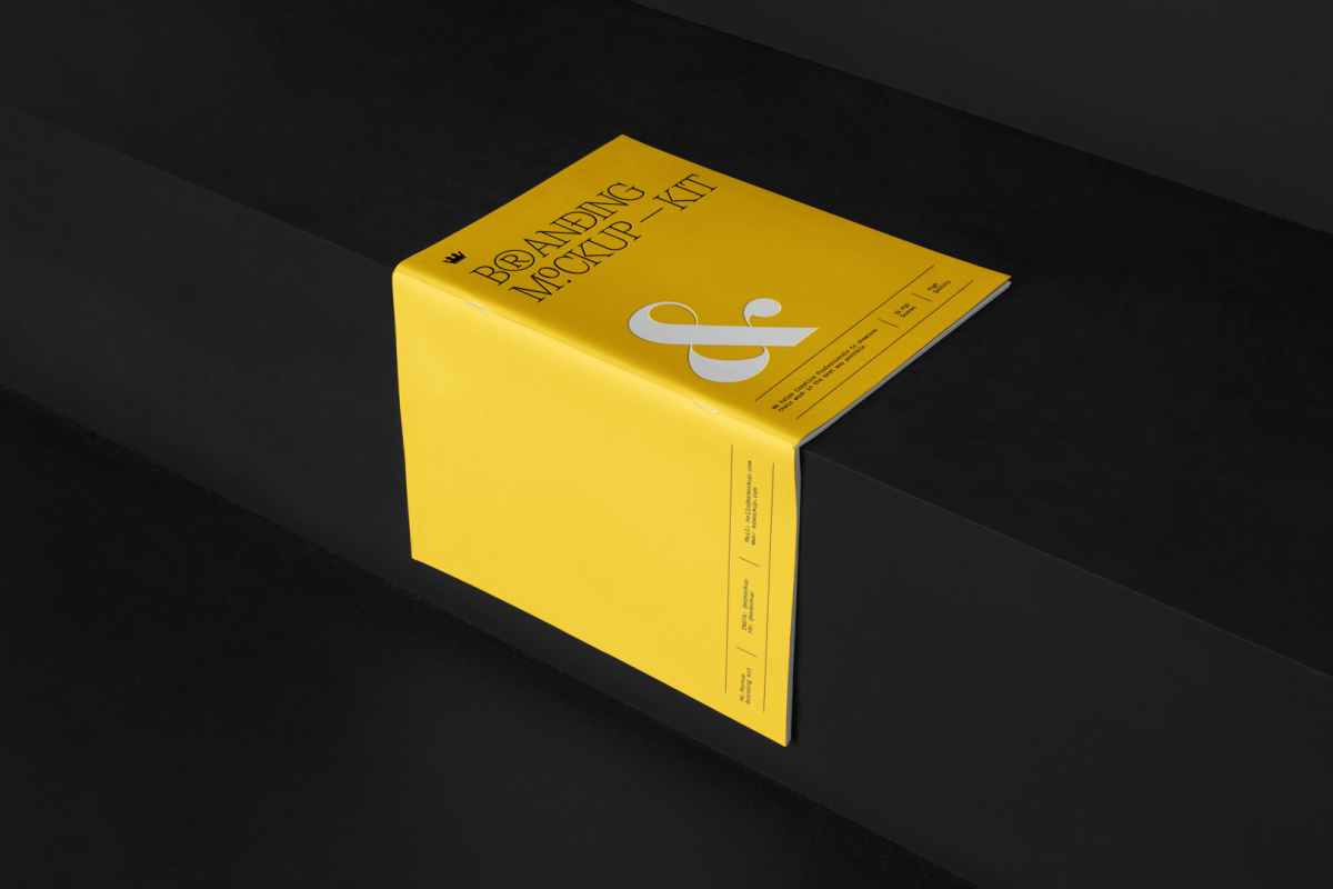 Notebook Branding Mockups Kit with yellow design seen from above and located on the black wooden stairs.