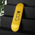 Skateboard Deck Branding Mockups Kit with yellow design seen from above and located on the black wooden stairs.