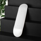 The White Skateboard Deck Branding Mockups Kit seen from above and located on the black wooden stairs.