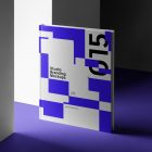 Seen from the front, Hardcover Book Branding Mockup standing on a purple floor between white walls.