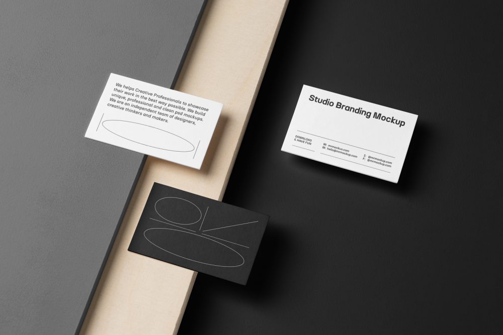 Three Business Cards Branding Mockups seen from the above laying on gray, black boxes and wood texture.