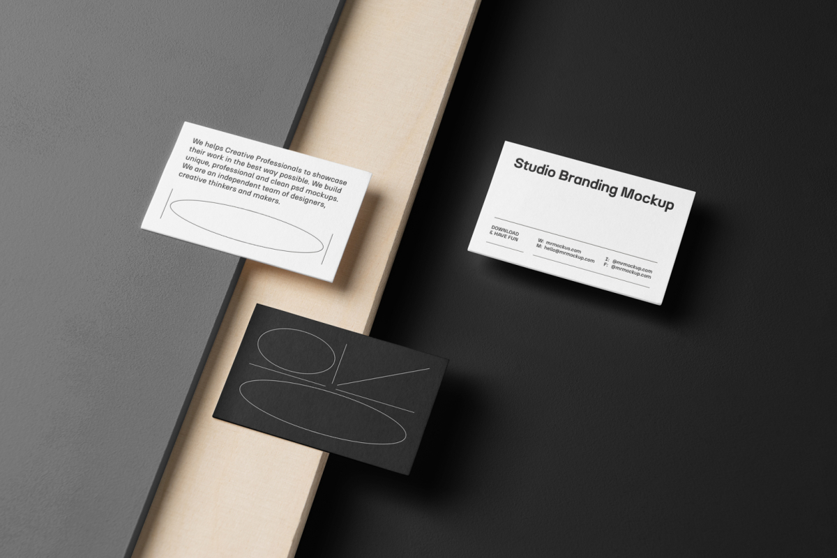 Three Business Cards Branding Mockups seen from the above laying on gray, black boxes and wood texture.