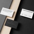 Three Business Cards Branding Mockups seen from the above laying on gray, black boxes and wood texture.