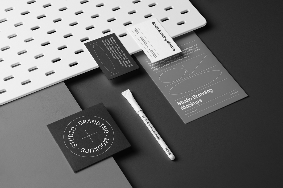 A set of Branding Mockups elements like business cards, envelope, pen, and company paper in composition with texture seen from the above laying on a gray box and black background.