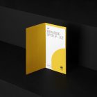 Leaflet Branding Mockups Kit with yellow design seen from front and located on the black wooden stairs.