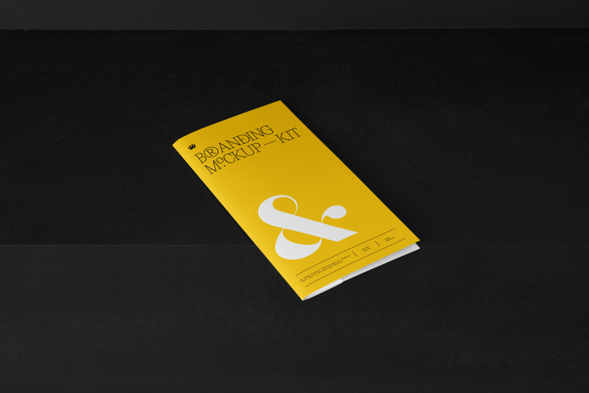 Leaflet Branding Mockups Kit with yellow design seen from above and located on the black wooden stairs.