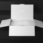 Blank Packaging Box Branding Mockups Kit with bubble foil is seeing from front and located on the black wooden stairs.