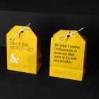 Two Decorative Paper Bags Branding Mockups Kit with a yellow design seen from above and standing on the black wooden stairs.