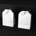 Two White Decorative Paper Bags Branding Mockups Kit seen from above and standing on the black wooden stairs.
