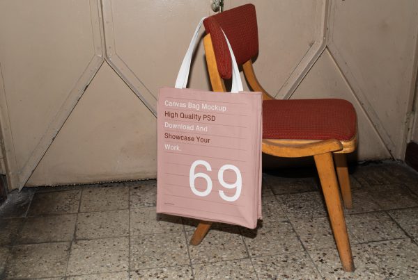 Front view, Free Canvas Bag Hanging on Chair Mockup with bright red inside the vintage magazine.